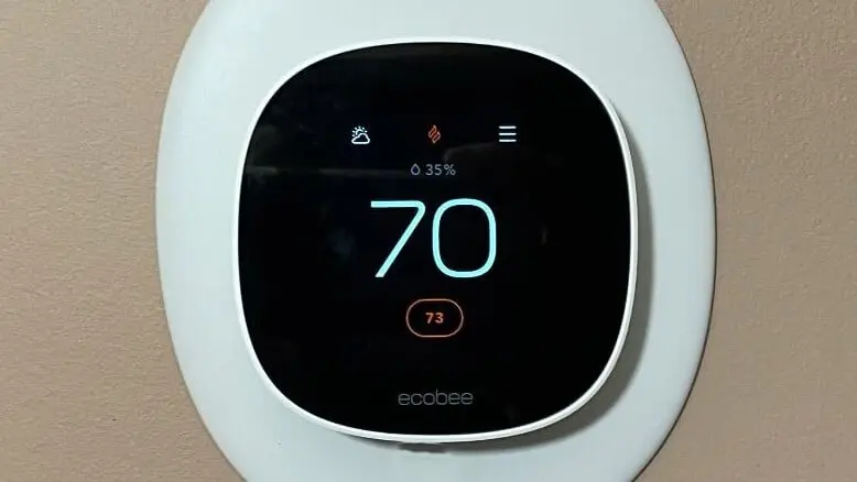 An Ecobee thermostat mounted on the wall, showing 70°F inside and a 73°F setpoint.